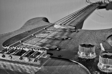 Vintage electric guitar in close-up, showcasing dusty strings and control knobs. Rich textures and nostalgic atmosphere make it perfect for music and retro-themed projects