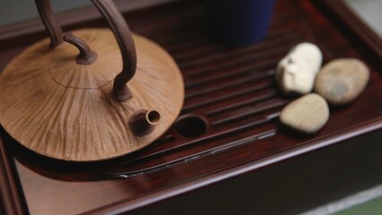 A Traditional Tea Set featuring Natural Stones elegantly arranged on a Wooden Tray. Media
