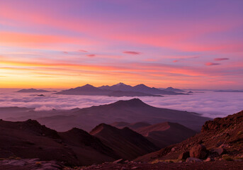 majestic mountain ranges at sunset with colorful twilight sky and misty fog flowing between peaks for travel inspiration
