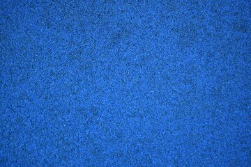 Blue sports field rubber coating close up macro view. Playground paving background texture...