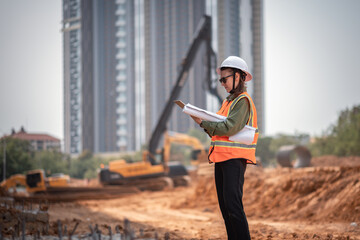 Engineer worker operations construction plans large black drainage pipe installing underground...