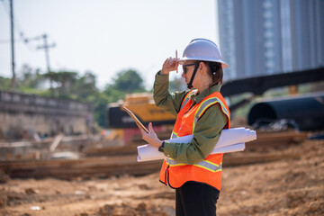 Engineer worker operations construction plans large black drainage pipe installing underground...