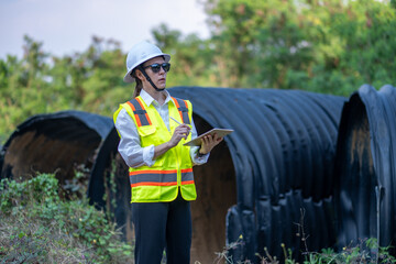Construction surveyor or engineer working inspection damaged black corrugated pipe and construction...