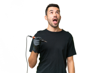 Tattoo artist caucasian man over isolated background looking up and with surprised expression