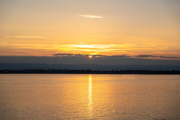 Sunset over the ocean, with the sun low on the horizon, contrast between sky and sea