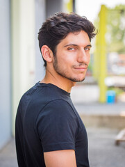 Headshot of one handsome young man in urban setting