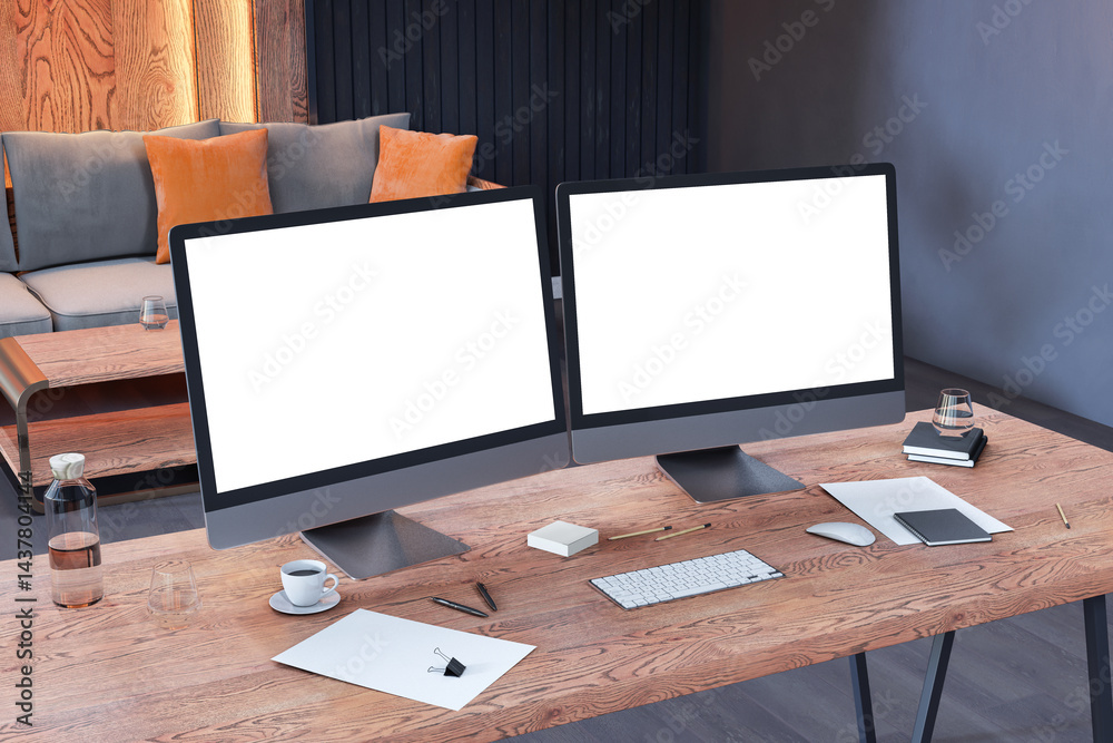 Poster dual blank computer monitors on wooden desk in modern office interior with sofa and ambient lighting