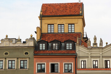 Traditional European architecture with vibrant facades, red clay roof tiles, dormer windows, and ornate exterior wall decorations in a picturesque old town setting
