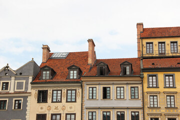 Fototapeta premium Traditional European architecture with vibrant facades, red clay roof tiles, dormer windows, and ornate exterior wall decorations in a picturesque old town setting