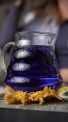 A Beautiful and Vibrant Blue Herbal Drink Served in a Glass Pitcher for Refreshment. Media