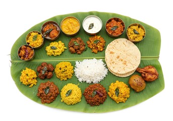 Traditional south indian thali meal on leaf isolated on white background