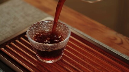 Pouring tea into a textured glass cup creates a calm atmosphere and showcases handcrafted luxury. Media