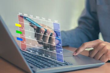 Businessman uses index finger to set agenda on calendar as appointment planning concept.	