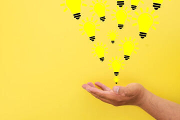A hand reaching up to falling Glowing light bulbs,representing creativity thinking,...