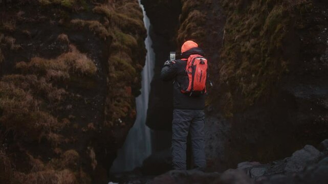 Man Standing Beside Majestic Icelandic Waterfall