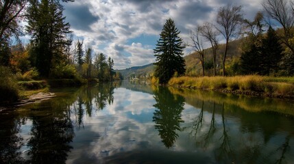 Obraz premium Idyllische Flusslandschaft mit dramatischem Himmel und Bäumen 