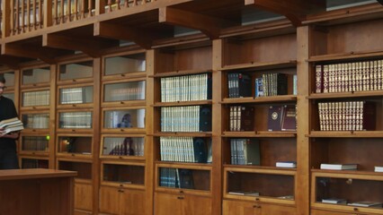An Elegant Collection of Beautiful Wooden Library Shelves, Filled to the Brim with Numerous Books. Media