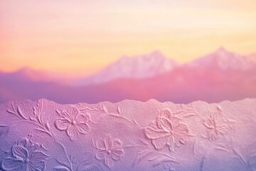Fototapeta premium Embossed floral pattern on a textured surface, soft sunset mountains in the background.