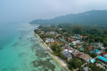 Naklejka premium Coastal town nestled beside turquoise waters and lush mountains