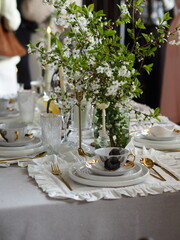 Beautiful aesthetic laid table. Decor. Dishes on the table. Spring bouquet