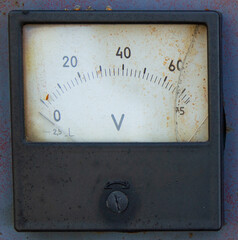 Close-up of a square analog voltmeter with a scale from 0 to 60 