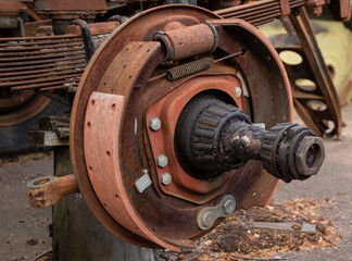 Close-up of a heavily rusted drum brake assembly with brake shoes, springs, and a wheel hub.