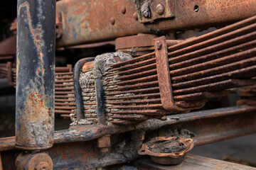 badly rusted leaf springs and shock absorber, part of the car's suspension.