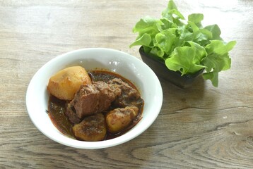 beef curry or Mussamun Indian food with slice potato on bowl eat with fresh green oak