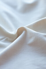 A serene close-up of soft, flowing fabric, capturing gentle curves and subtle textures in a...