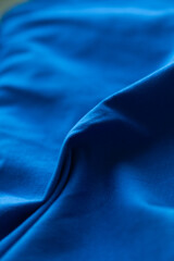 Experience the vibrant energy of this captivating blue fabric, with its smooth texture and dynamic folds creating a mesmerizing visual.