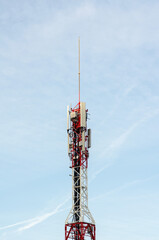 A modern telecommunication tower with multiple antennas transmits mobile and wireless signals,...