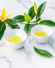 Bright Yellow Liquid in White Bowls with Green Leaves and Yellow Flower on Marble