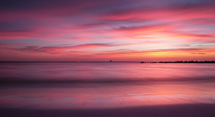 Naklejka premium Majestic Seascape At Dusk With Vibrant Hues Of Pink And Orange