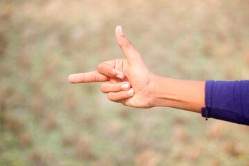 A man pointing two fingers of his hand forward and green background