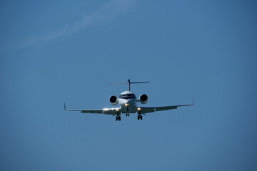 Airplane in the blue sky. Business jet preparing for landing