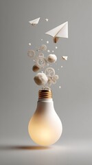 Conceptual innovation display with lightbulb, gears, cotton balls and paper planes