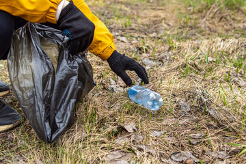 A man collects plastic garbage in nature