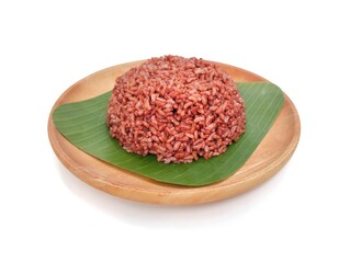 Red rice on wooden plate isolated on white background 
