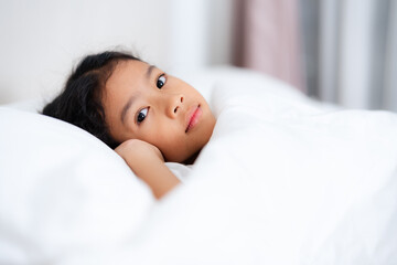 Little girl sleeping peacefully in white bedding