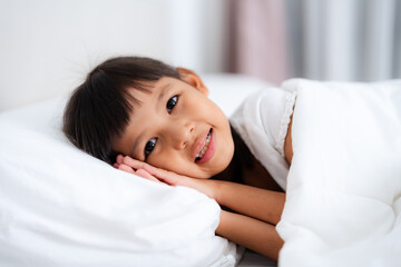 Little girl sleeping peacefully in white bedding