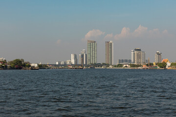 Naklejka premium A panoramic view of Bangkok's Bang Pho district, with the Chao Phraya River flowing gracefully in the foreground where urban charm meets riverside serenity