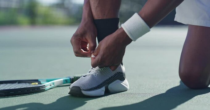 Tennis, fitness and hands tie shoes to start exercise, match and sports competition. Legs, outdoor and person tying laces on sneakers in preparation for training or ready to play game on turf closeup