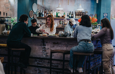 A lively atmosphere at a modern lounge bar with people socializing while food is served.