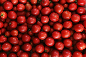 A pile of fresh, ripe red tomatoes closely packed together.
