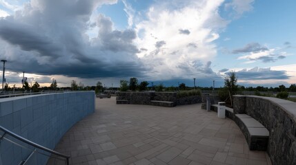 A wide-angle view captures the serene empty outdoor amphitheater under a vibrant twilight sky, showcasing tiered stone seating and open space for cultural events
