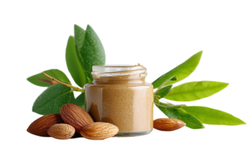 A jar of creamy almond butter surrounded by fresh almonds and green leaves on a clean background