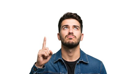 Fototapeta premium A young man with a beard looks upwards and points with his index finger, isolated against a plain white background in a studio shot.