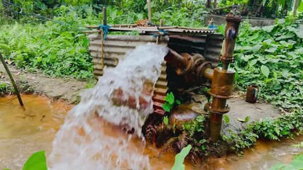 Traditional Deep Tubewell Pump System Discharging Water Rapidly into a Rural Canal for Agricultural Irrigation