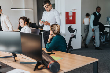 Multicultural employees focused on tasks in a bright open office. The image conveys professionalism, teamwork, and diversity in a modern workspace setting.