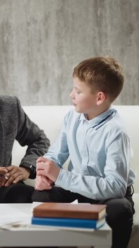 Smart little students answer smiling African-American educator in glasses questions during English lesson with native speaker at home slow motion
